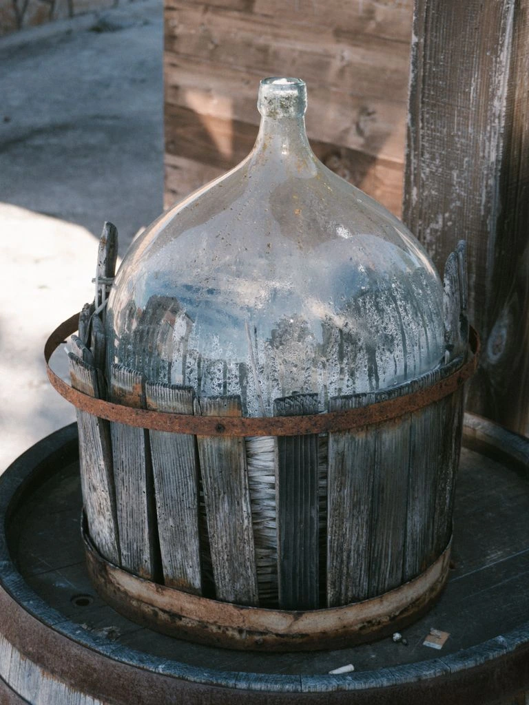 Patinated Roman glass jug with applied handle showing iridescent weathering