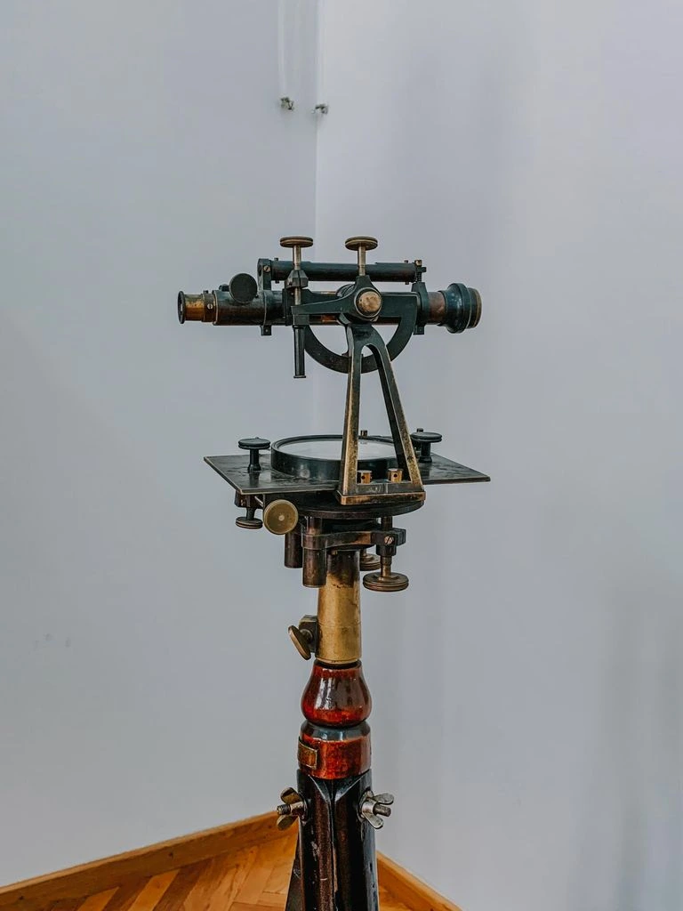 Antique brass universal theodolite on mahogany tripod with engraved scales